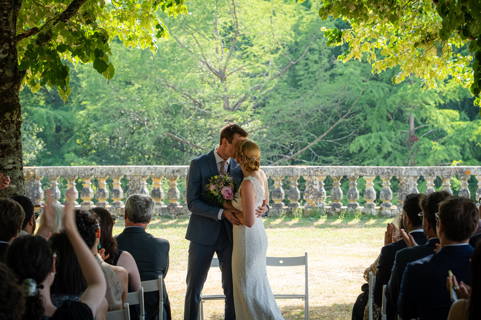Photo de mariage : baiser des mariés dans un jardin