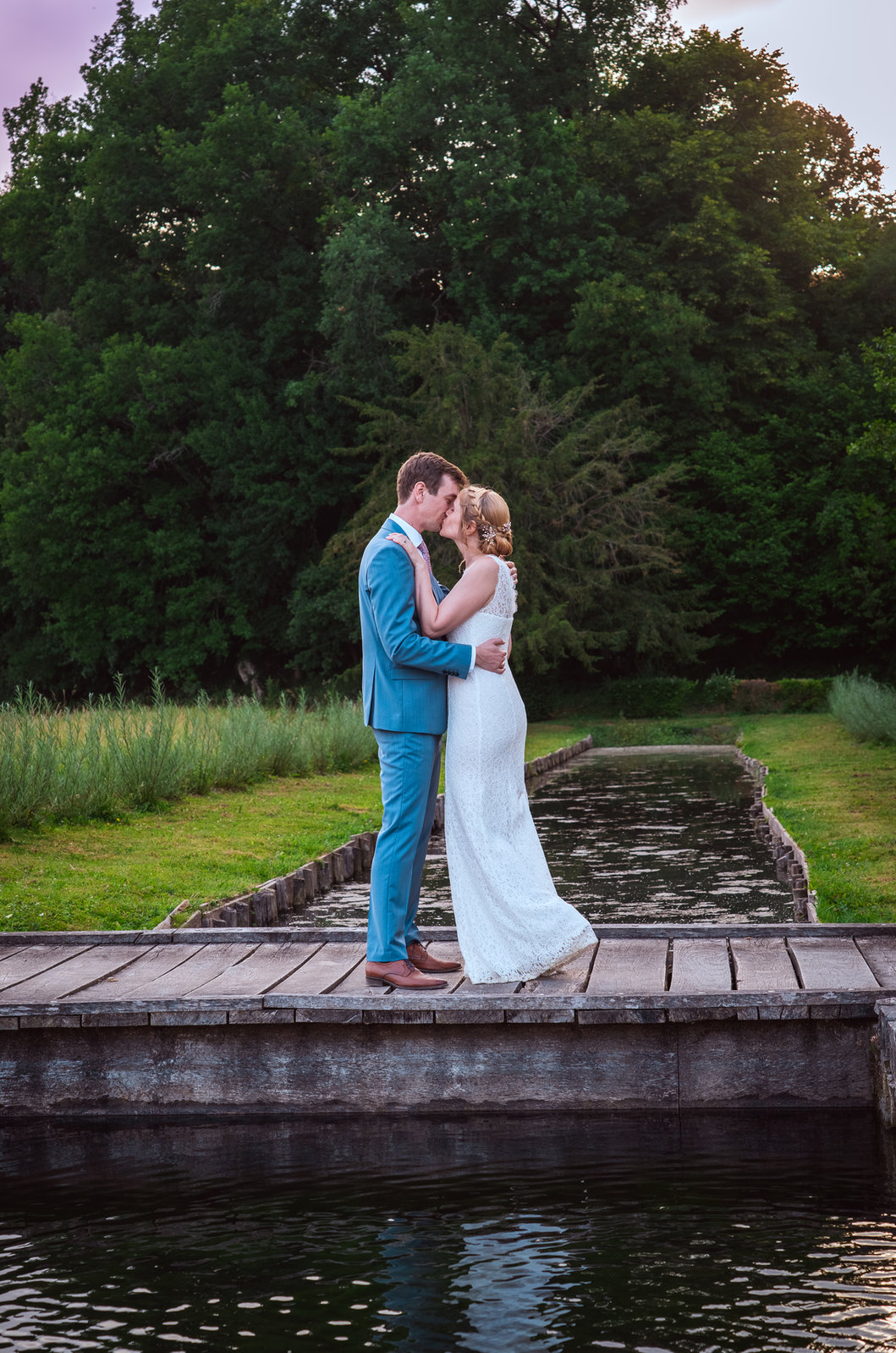 Photo de mariage : les mariés s'embrassent sur un ponton