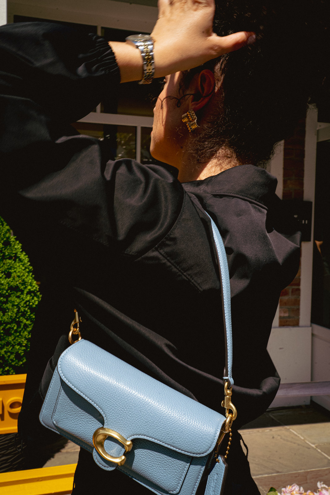 Photo de mode : sac à main bleu porté à l'épaule